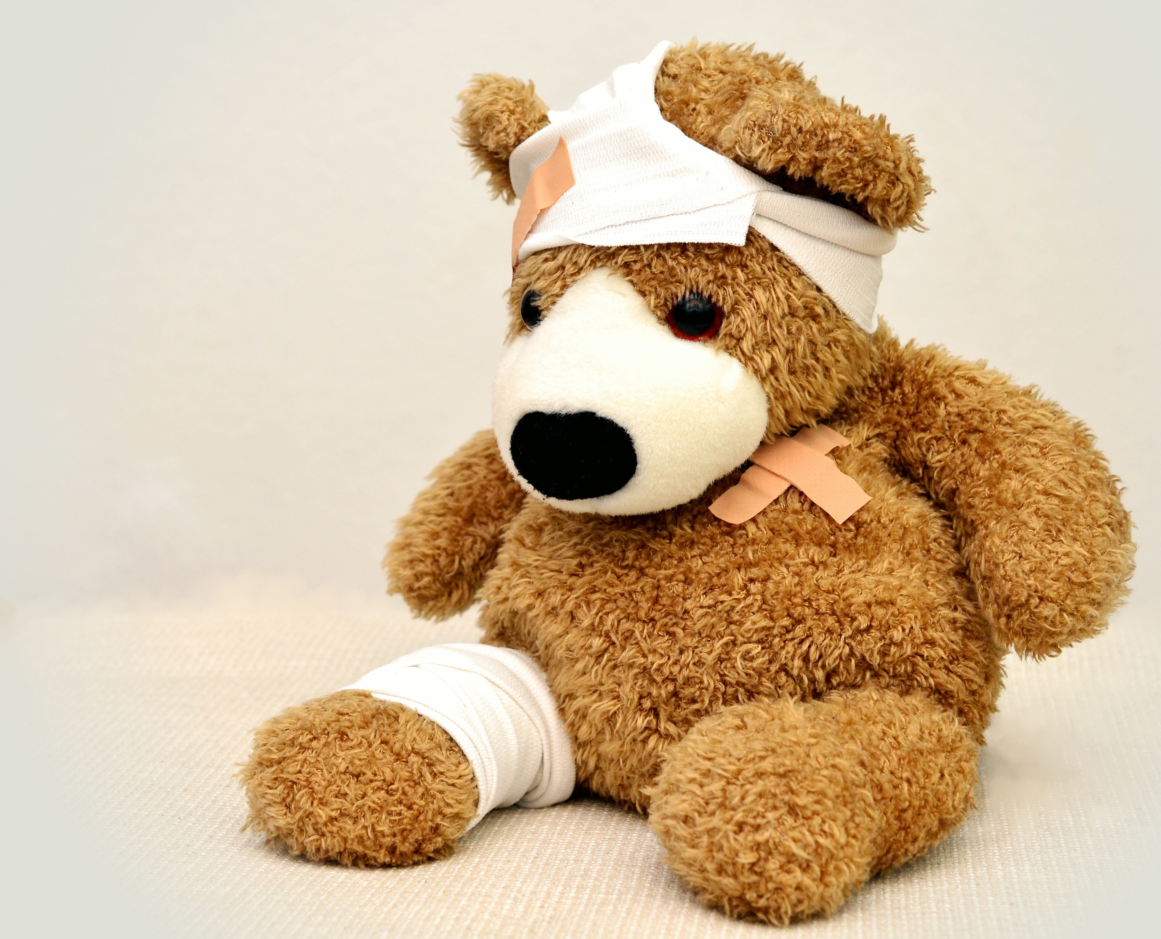 Brown and white bear with bandages